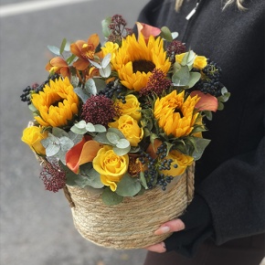 Композиция в сумке "Тональность" из подсолнухов, калл, ягод вибирнума, лимонных роз, скиммии и орхидеи в Павловском Посаде
